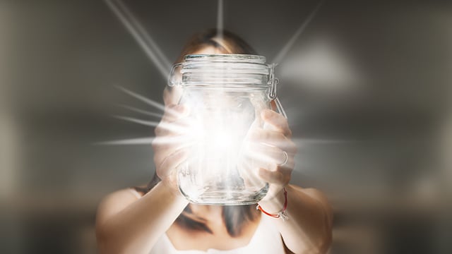 woman holding glowing glass jar 640x360