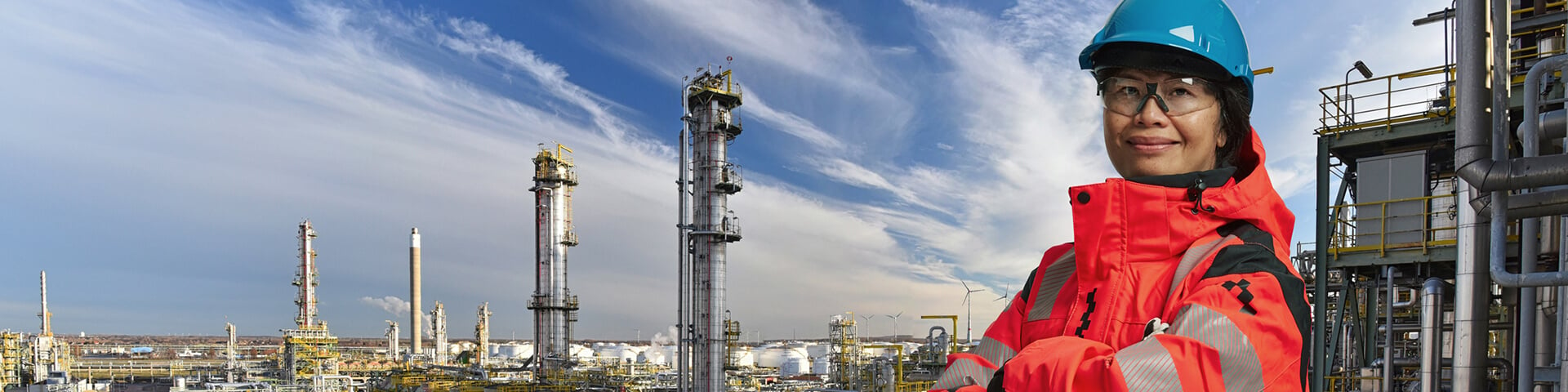 female asian engineer infront of refinery banner