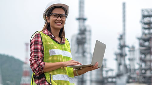female engineer outside industrial plant with tablet