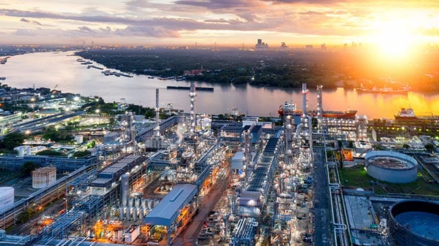 industrial plant by river in sunset