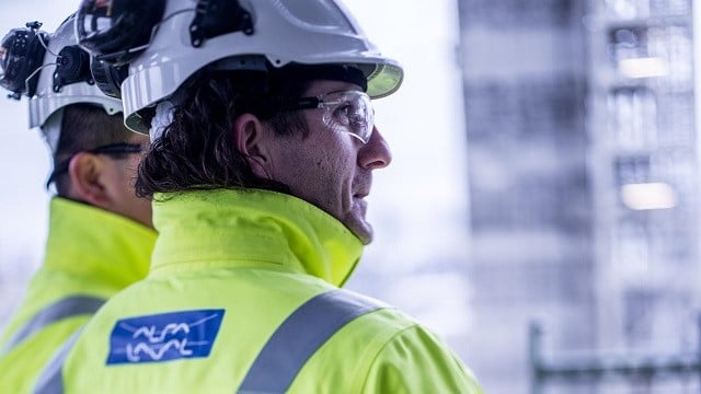 Two men with helmets and Alfa Laval jackets