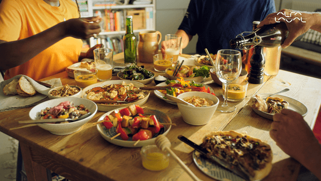 Group of friends enjoying dinner together around a table, sharing food and conversation.