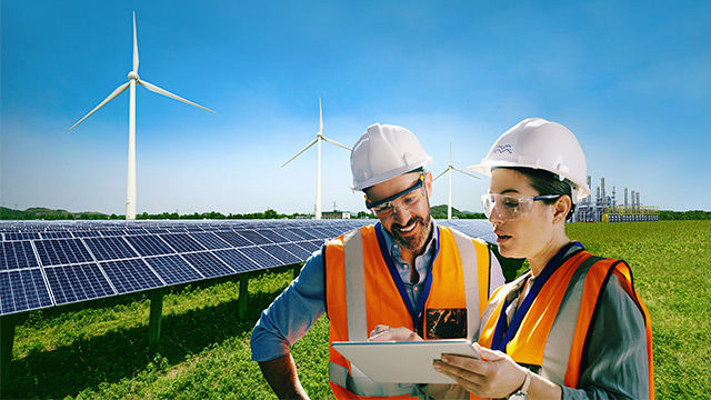 Two engineers discussing plans, surrounded by sustainable sources of energy generation 