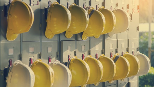 Several yellow helmets hanging on a wall