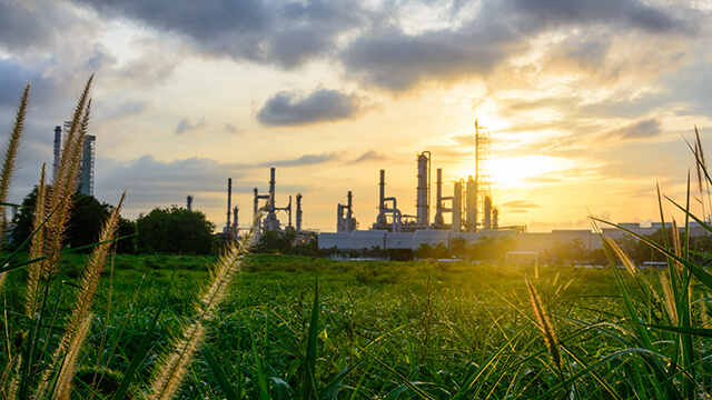 oil-refinery-green-grass-plants-sunset