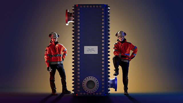 男性和女性工程师站在Alfa Laval Compabloc焊接板热交换器旁边亚博yabovip2020网址