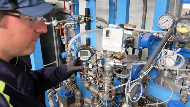 Man checking control system for Alfa Laval Compabloc welded plate heat exchanger